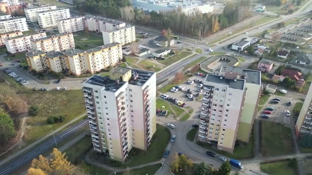 Panorama osiedla i dachów wieżowców z instalacjami fotowoltaicznymi.