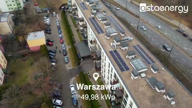 Budynek wielorodzinny z panelami fotowoltaicznymi na dachu.